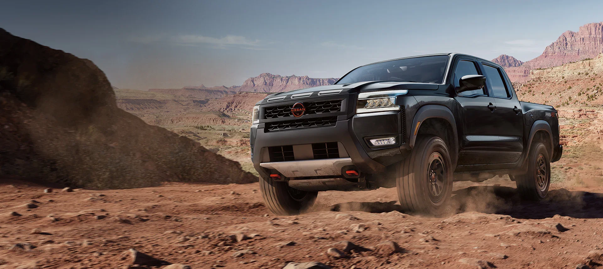 Nissan Frontier on a rocky outcrop in the mountains