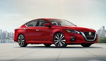 2023 Nissan Altima in red with city in background illustrating last year's 2022 model in Crown Nissan in St. Petersburg FL