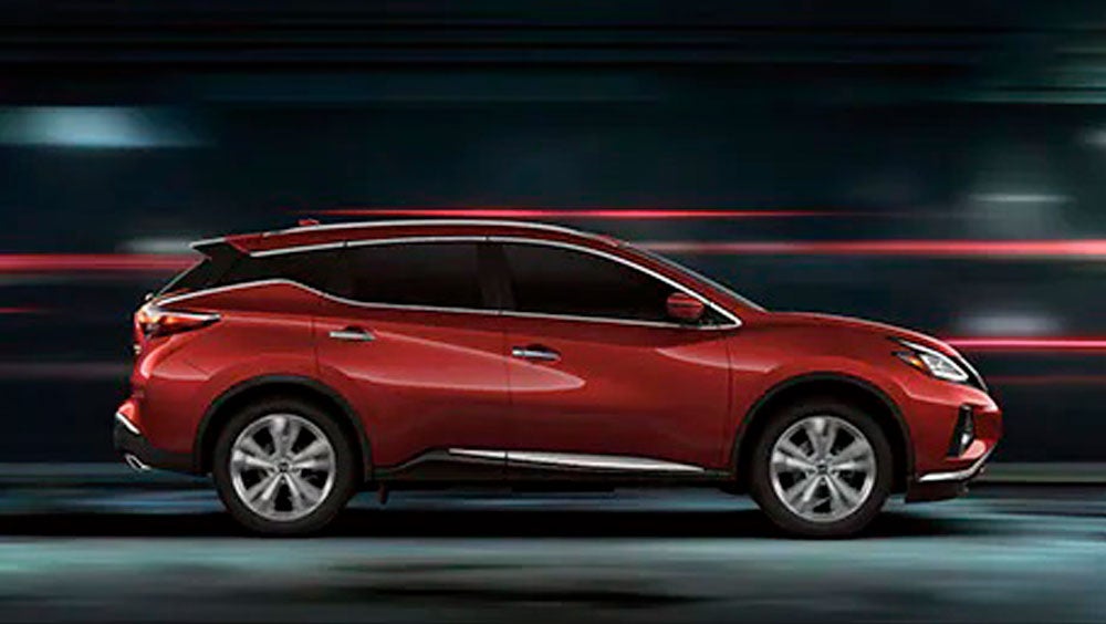 2023 Nissan Murano shown in profile driving down a street at night illustrating performance. | Crown Nissan in St. Petersburg FL